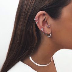 a woman wearing two different ear piercings