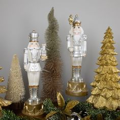 three glass nutcrackers standing next to each other near christmas trees and decorations