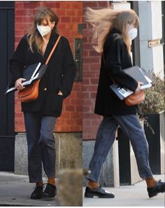 two women walking down the street wearing masks and carrying folders in their hands as they both wear face masks