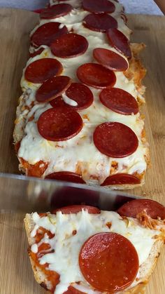 two slices of pepperoni pizza sitting on top of a cutting board