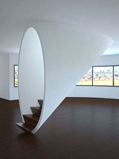 a spiral staircase in an empty room with large windows and wooden flooring on both sides