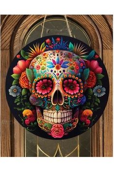 a clock with a colorful skull painted on it's face and flowers in the middle