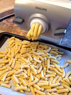 a pan filled with pasta being cooked on top of a stove burner next to a toaster