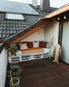 a small balcony with a couch and potted plants on the floor next to it