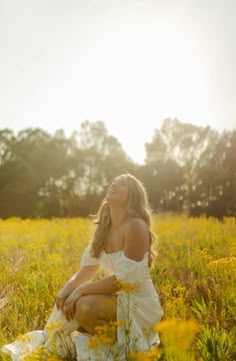 a woman is sitting in the middle of a field