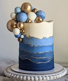 a blue and white cake with gold ornaments on top