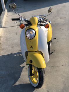 a yellow and white scooter parked on the street