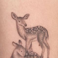 a deer and her baby are depicted in this tattoo