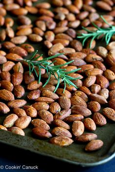 almonds with rosemary sprigs on a baking sheet