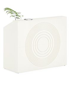 a plant is growing out of the top of a white box with circles on it