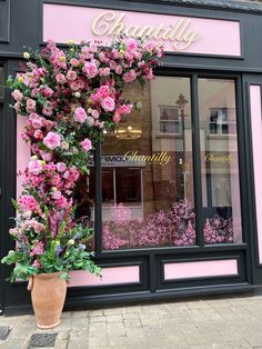 a flower shop with pink flowers in the window