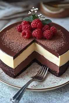 a chocolate cake with raspberries on top and a slice taken out of it