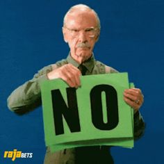 an older man holding up a sign with the word no on it in front of his face