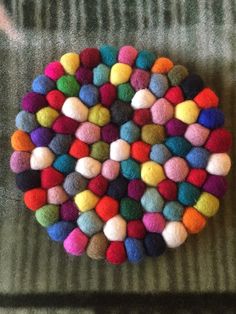 multi colored pom - poms arranged in the shape of a circle on a couch