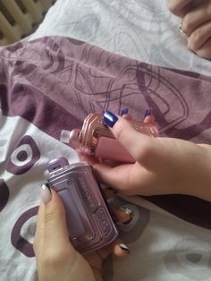 a woman is holding two different types of perfumes in one hand and an empty bottle in the other