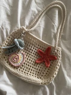 a crocheted purse with starfish and seashells hanging from it's handle