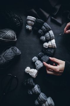 someone is knitting yarn together in a circle on a table with crochet hooks