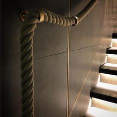 the rope is attached to the wall next to the stairs with lights shining on it