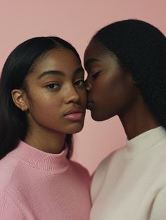 two women in pink sweaters kissing each other