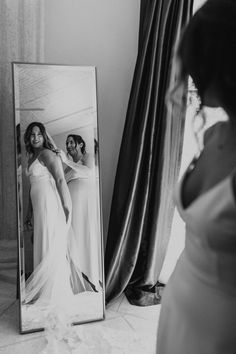 a woman standing in front of a mirror