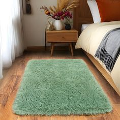 a green rug on the floor in a bedroom