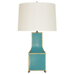 a blue lamp with a white shade on it and a gold trim around the base