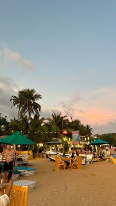 people are sitting at tables on the beach