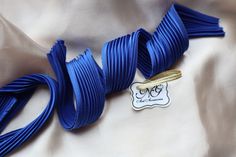 a close up of a blue ribbon with a tag attached to it's end