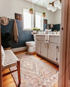 a bathroom with a rug, sink and toilet in it's center piece is shown