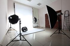 an empty room with two photography equipment and one light set up in front of the camera