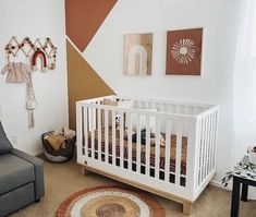 a baby's room with a grey couch and white crib