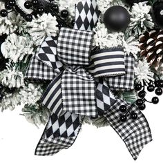 a black and white christmas tree decorated with bows, baubs and pine cones