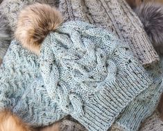 a knitted hat with two pom - poms on the top and one in the middle