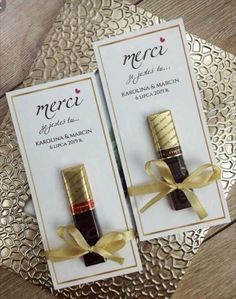 two small bottles with gold ribbon on them