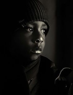 a black and white photo of a person wearing a beanie looking at the camera