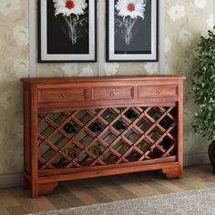 two framed pictures hang on the wall above a wooden console