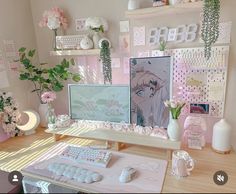 a desktop computer sitting on top of a wooden desk next to a vase with flowers