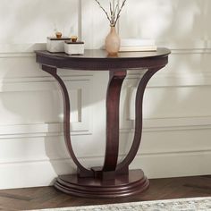 31" wide x 32" high x 17 1/4" deep. Weighs 35.86 lbs. Bentley wood console table. Half-round base and top with curved support legs. From the 55 Downing Street brand of furniture. Half-round table design allows you to place it flush to a wall. Dark oak brown finish. Wood and wood laminate construction. Ships flat. Assembly required, hardware included. 
A rich brown finish enhances this curvy wood half-round console table.
Additional Info: 
Sleek curves form a romantic silhouette that makes this wood console table stand out in any space. A vintage attitude stylizes its personality, making it a perfect choice for an entryway, main living space, or bedroom. Brown finish over wood construction adds a rich look, as an open body with curving supports rests on a stacked base. Apron grooves along i Round Foyer Table Decor Entryway, Round Console Table, Round Foyer Table, Half Round Table, Sofa Table Design, Half Moon Console Table, Bedroom Brown, Console Table Lamp, Romantic Silhouette