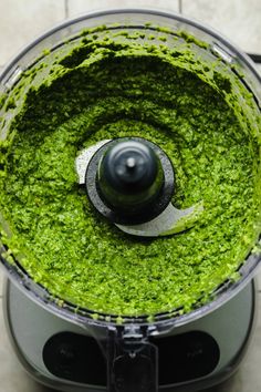 a food processor filled with green pesto