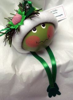 a stuffed animal with a green ribbon around it's neck and head on a white sheet