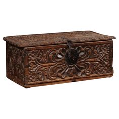 an ornate wooden box with carvings on the lid and sides, sitting against a white background