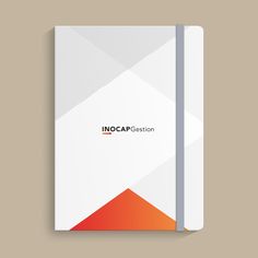 a white notebook with an orange triangle on the cover