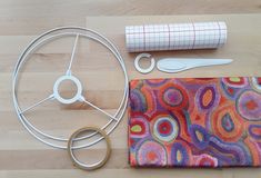 craft supplies including scissors, thread, and tape on a wooden surface with paper roll