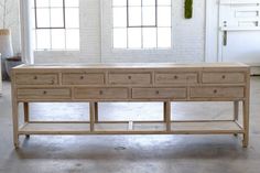 a large wooden table with drawers in an empty room