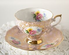 an antique tea cup and saucer on a lace doily