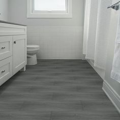 a bathroom with gray flooring and white walls