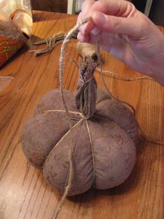 a person is stringing the top of a pumpkin on a table with twine