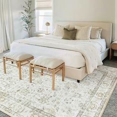 a bedroom with a large bed and two stools on the floor next to it