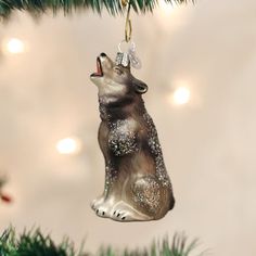 an ornament shaped like a dog is hanging from a christmas tree with lights in the background