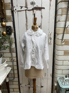 Antique French white brushed cotton blouse with lace collar initials LM size M. 100% Cotton - warm brushed cotton. Collar, button tab and button cuffs, all with embroidered lace trim, initials LM at hem. Size: Chest: 40 inches; Shoulder to shoulder: 15.5 inches; Sleeve length: 20 inches; arm inseam: 17 inches; Length: 23.5 inches. Weight: allow up to 1 kg once packed. Condition commensurate with age and use - a very small faint mark on front and original darn at back of neck but hidden by collar Fall Cotton Blouse With Lace Collar, White Top With Detachable Collar For Workwear, White Tops With Detachable Collar For Workwear, White Top With Detachable Collar For Work, White Shirt With Fold Down Collar For Fall, Cotton Blouse With Fold Down Collar For Daywear, Cotton Blouse With Lace Collar For Fall, Collared Cotton Blouse With Lace Trim, Classic Cotton Blouse With Lace Trim